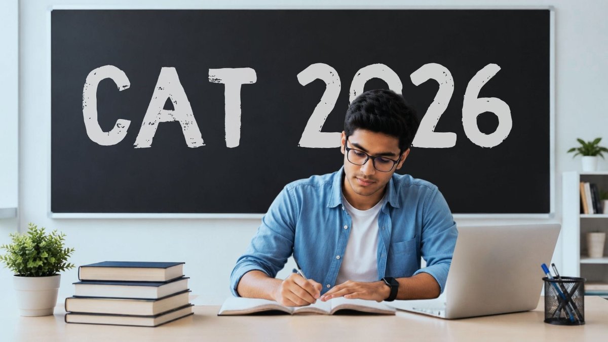 A desk with a laptop, notebook and a calendar marking the CAT 2026 MBA entrance exam date.